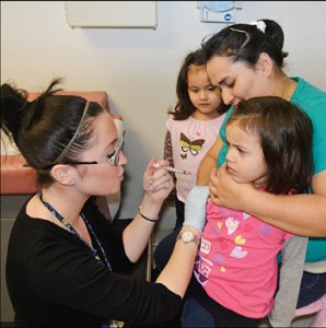 A family gets vaccinated at one of 20 free flu clinics set up by the Boston Public Health Commission on Saturday after Mayor Thomas Menino declared a public health emergency in Boston.